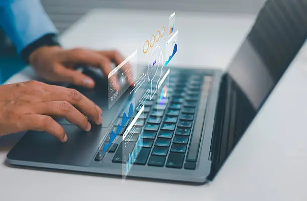 Photo of Businessman working on laptop with virtual data analytics dashboards AGI interface representing business intelligence, digital transformation automation machine learning modern technology solutions
