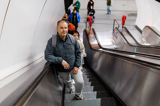 Two mature friends riding on subway station escalator