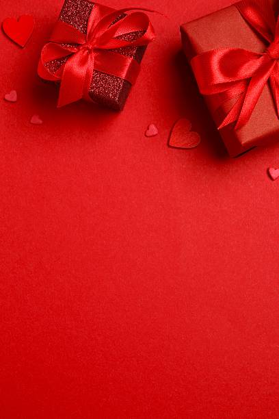 istock Valentine's Day flat lay with wrapped gifts and hearts creating a corner border on red background 2258448974