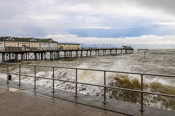 Stormy crashing waves and dramatic sky at Teignmouth Pier in Devon