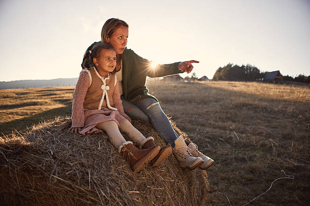 Happy girl in nature with mother. It’s beautiful autumn day. Sunset vibes.