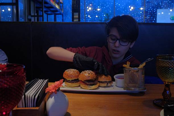 12 year old boy enjoying mini burger set in a cafe, fast food, weekend pleasure
