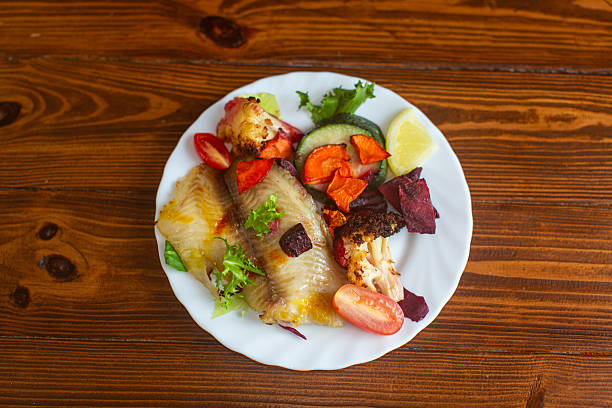 Gourmet baked fish dish with fresh colorful vegetables.