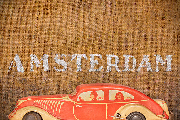 Antique model car in front of an old brown background with the text Amsterdam