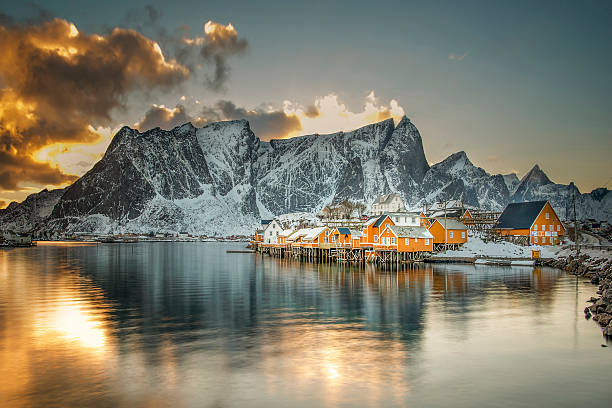 Wonderful landscape on Lofoten islands in winter season. Impressive Winter scenery with snowcapped mountains, traditional red fisherman huts, rorbuer. Hamnoy village of an ideal resting place.
