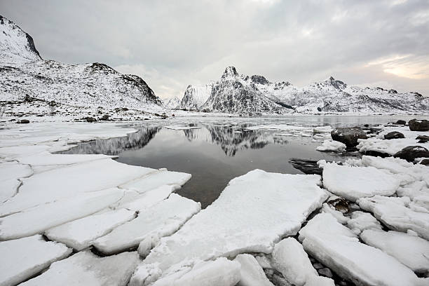 Wonderful landscape on Lofoten islands in winter season. Impressive Winter scenery with snowcapped mountains, traditional red fisherman huts, rorbuer. Great place to observe aurora borealise phenomenon.