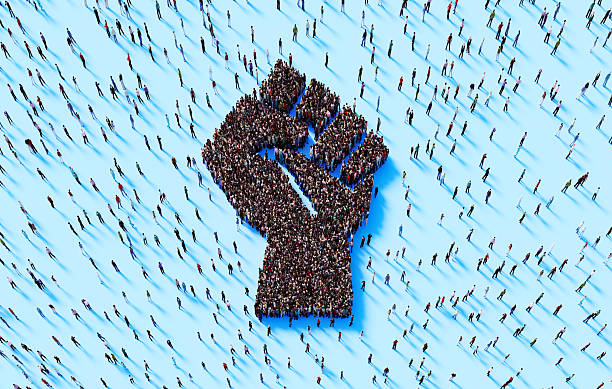 Human crowd forming human fist symbol on blue background. Freedom concept.