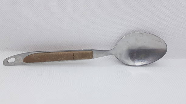 A detailed product photograph of a vintage-style large serving spoon featuring a long, wide, polished stainless steel bowl with subtle wear marks and shine, attached to a warm brown wooden handle with natural grain and aged patina. The handle includes a small hanging hole near the end. Shot against a clean white background, ideal for rustic kitchenware catalogs, vintage utensil listings, farmhouse decor, retro dining, and traditional cooking tool photography.