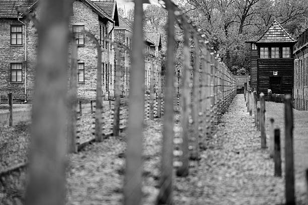 Electric fence and brick barracks at Auschwitz memorial site