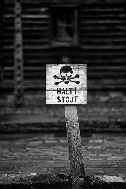 Skull warning sign in front of camp barracks at Auschwitz