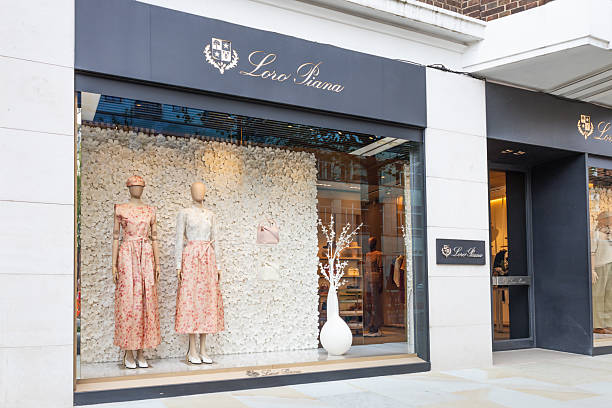 Loro Piana luxury fashion boutique storefront featuring designer dresses on mannequins behind a glass window display. London, UK, 6 April 2024