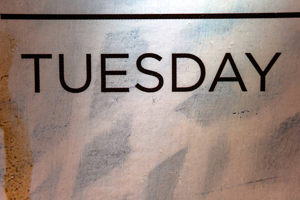 Macro composition of the inscription Tuesday on a dirty sticker.