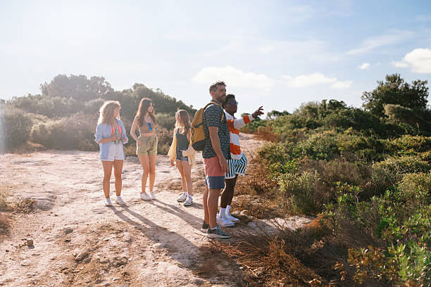 Group hiking toward hidden beach along coastal path