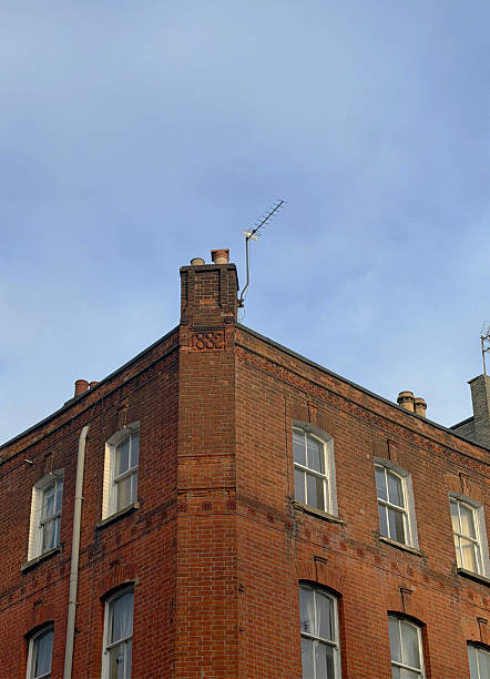 Just the top floor of an old, angled building, made of brick and capped in 1882. Fitzrovia neighborhood, London UK 2026
