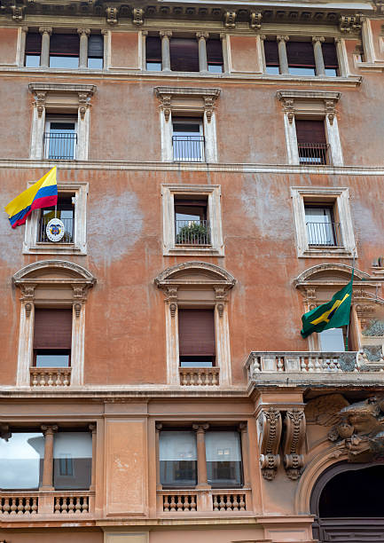 January 19, 2026, Vatican City, Italy, Flags of Colombia and Brazil hang from a historic Renaissance facade with shuttered windows and balconies, marking a diplomatic presence in the heart of the Vatican.