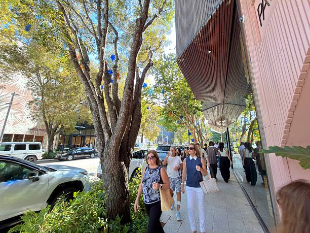 Miami, Florida, United States of America - January 11, 2026: Shoppers and tourists stroll sunny NE 1st Avenue amid upscale boutiques and sleek modern architecture in Miami Design District, enjoying retail, art and urban outdoor life