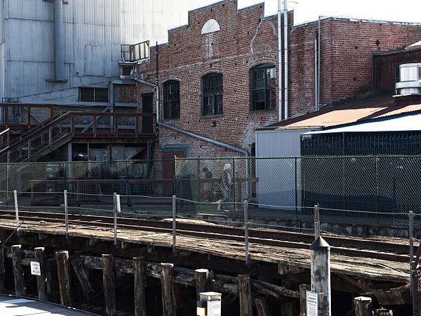 Old train tracks and agricultural processing facility along the waterfront of Petaluma California, now a retail and dining hub.