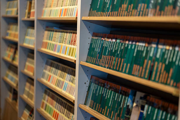 New York, USA - January 11, 2016: Collection of travel guide books consisting of lonely planets for countries in asia and africa on a bookshelf with book of Thailand sticking out