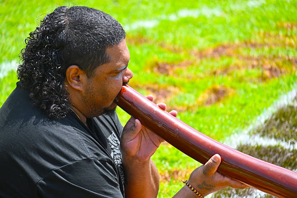 Coffs Harbour, Nsw - Jan 26 2026:Adult Indigenous Australians man play Aboriginal music with didgeridoo wind instrument.Aboriginal music featuring the didgeridoo (traditionally known as Yidaki or Mako) is one of the world's oldest continuous musical traditions, dating back over 1,500 years.