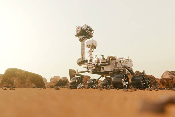 Detailed 3D render of a robotic rover on the dusty Mars surface. High-tech space vehicle exploring rocky terrain under a bright hazy sky. Concept of planetary science and future space missions.