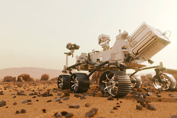 High-angle 3D render of a robotic Mars rover exploring a rocky, orange desert. Detailed view of wheels and scientific equipment on the Martian surface. Futuristic space exploration and planet mission.