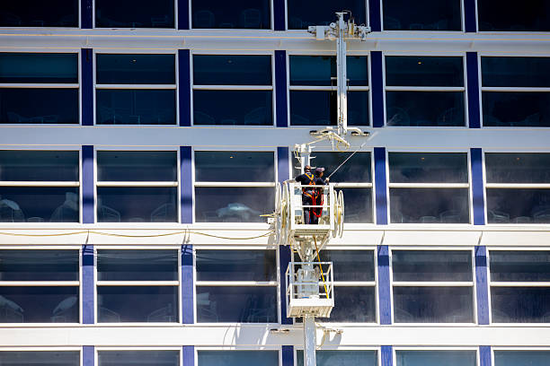 Sydney, Australia - 25 January 2026: Two window washers cleaning side of cruise ship docket at Circular Quay Sydney Harbour, which serves cruise ships and ocean liners.