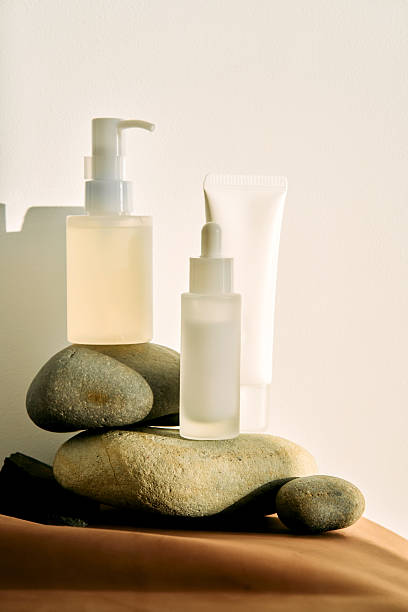 Skincare products balancing on natural stones in sunlight