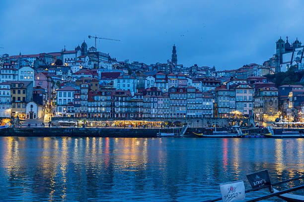 Porto, Portugal, 11 Jan 2026: Night Skyline Over Douro With Warm Facade Lights, Calm River Reflections, Illuminated Streets, Atmospheric Urban Glow, Historic Silhouette Against Deep Blue Sky