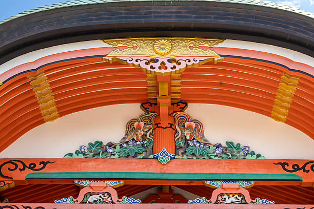 Kyoto, Japan - December 06, 2025: Vibrant details of a traditional Japanese temple's ornate roof structure, showcasing intricate carvings of phoenixes, golden crests, and colorful patterns.