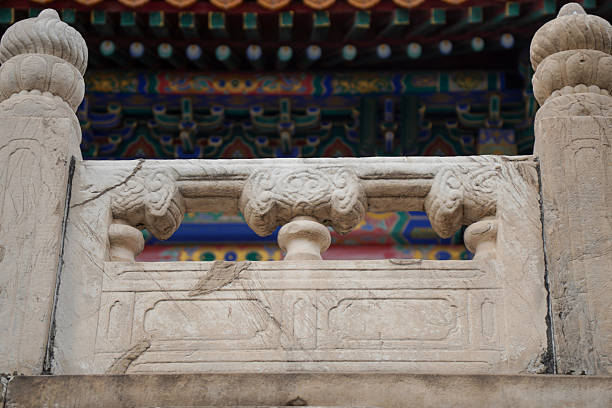 Close-up of an ornate stone railing with traditional Chinese architectural carvings, showcasing detailed craftsmanship and cultural heritage.