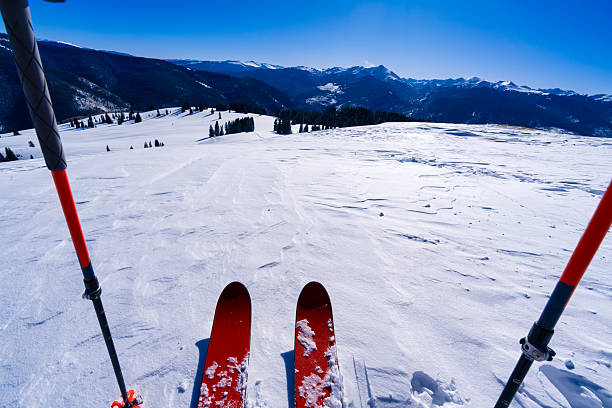 Pair of skis in snow with copy space. Snowy skis standing in snow with winter mountains in background. Winter Holiday Vacation and recreational sports skiing concept