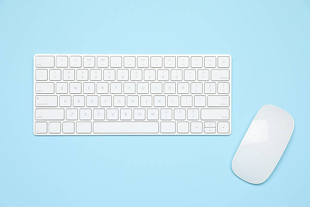 A close-up of hands typing on a sleek, modern keyboard on a white office desk, and using computer mouse symbolizing productivity and efficiency in a professional workspace