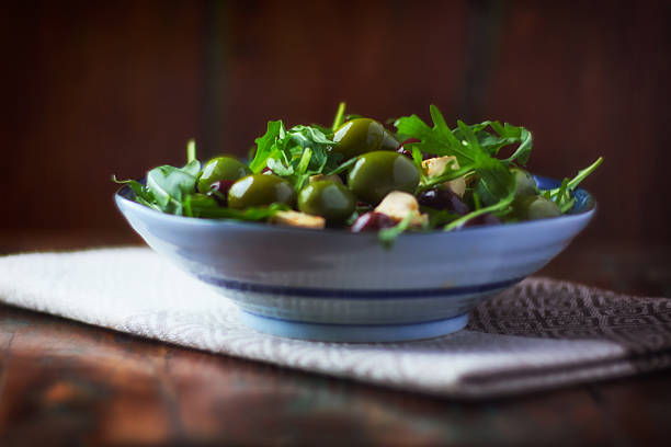 Salad with feta cheese, green olives and arugula. Selective focus