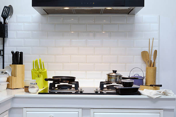 A vintage stove stands prominently in a charming kitchen adorned with intricately patterned tiles. The delicate blue and white designs create a stunning backdrop for the classic appliance, while hints of green cabinetry add warmth.