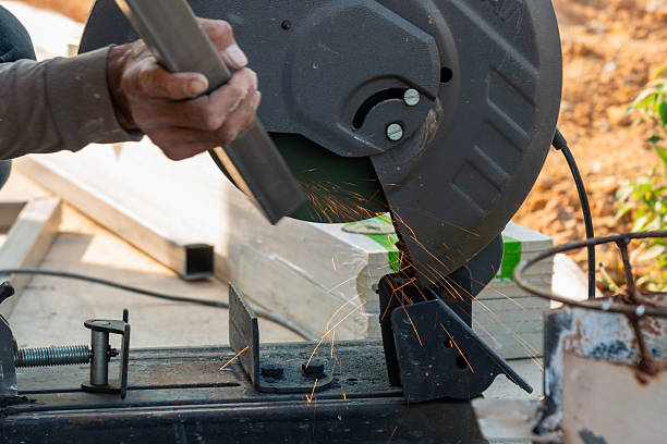 A craftsman uses a cutting tool creating sparks in a workshop showcasing industrial precision.
