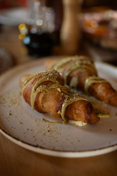 Delicious Croissant Pastries Drizzled With Cream Sauce on White Plate, Breakfast Favorite