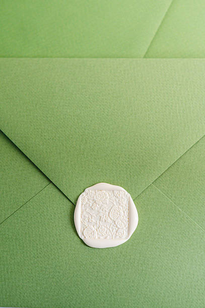 Flat lay of a green envelope sealed with white wax stamp, representing wedding invitations, luxury stationery, branding, correspondence, and elegant design.