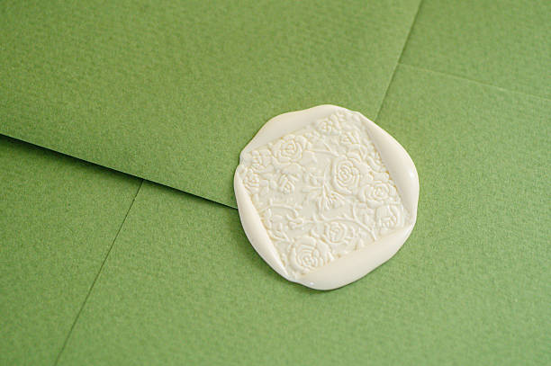 Green envelope sealed with white wax stamp, representing invitation, wedding stationery, luxury correspondence, branding, tradition, and handmade concepts.