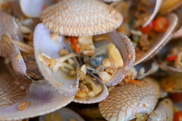 Thin-shelled saltwater clams prepared in a flavorful oyster sauce, complemented by fragrant ginger, garlic, and onions for a classic seafood dish.