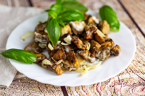 Appetizing eggplant pieces with sauce and fresh basil leaves