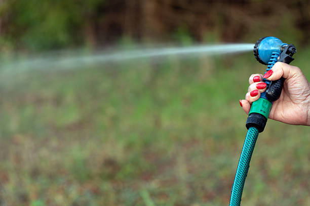 Senior man in watering the garden with garden hose