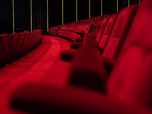 Modern cinema red leather seats with shallow depth of field, LED accent lighting and dark walls