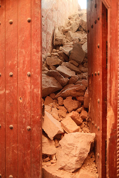 Debris filling a doorway of a traditional Moroccan building after an earthquake, highlighting destruction and tragedy
