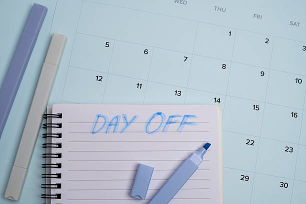 Day off text handwritten in notebook on monthly calendar. Work life balance and vacation planning concept.