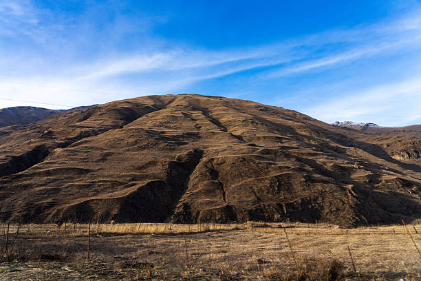 Dry hills forming a mountain highland landscape with minimal vegetation. Suitable for nature and environment backgrounds.
