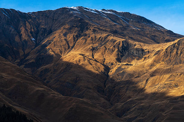 Dry mountain slopes with strong light and shadow in arid highland landscape. Suitable for environment, geology, and background use.