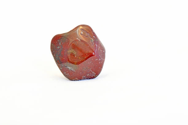 A detailed macro shot of a polished bloodstone mineral specimen showing characteristic deep red and dark green jasper patterns, isolated on a white background.