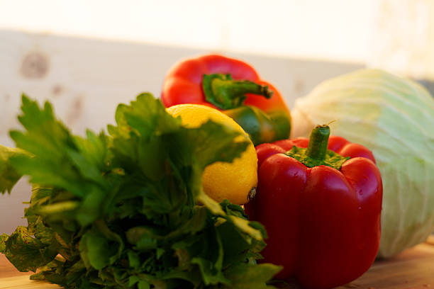 Vegetables including red pepper, lemon, white cabbage, and infected celery leaves affected by the fungal disease Cercosporin leaf spot.