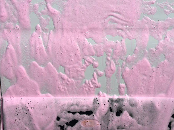 Covered auto with pink foam at a self-service car wash