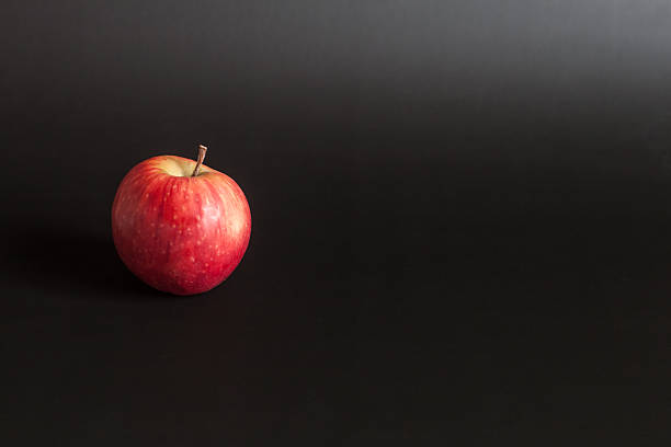 Ripe red apple on a dark (black) background.